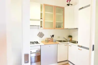 a small kitchen with white cabinets and a sink at Romantic Flat near Metro Flaminio in Rome