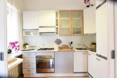 a kitchen with white cabinets and a stove top oven at Romantic Flat near Metro Flaminio in Rome