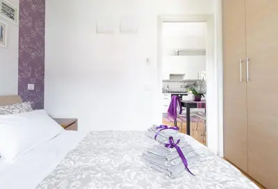a bedroom with a bed with a purple ribbon on it at Lambertone, cozy flat in Rome, Aurelio Vatican in Rome