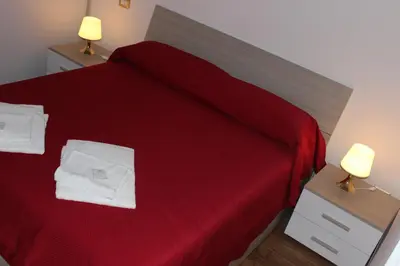 a bedroom with a red bed with towels on it at Locazione Turistica 