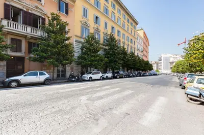 an empty street with cars parked on the side of a building at Lovely and modern nest near the Colosseum in Rome