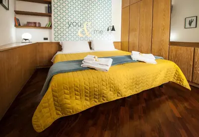 a bedroom with a yellow bed with towels on it at Rome As You Feel - Baccina 95 Forum Apartment in Rome
