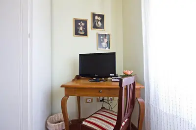 a desk with a computer monitor on a desk with a chair at B&B Roma Appia Davila25 in Rome