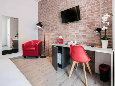 a room with a desk and a red chair at Lele Rooms San Lorenzo in Rome