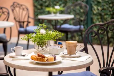 a table with two cups of coffee and pastries on it at Hotel Della Conciliazione in Rome