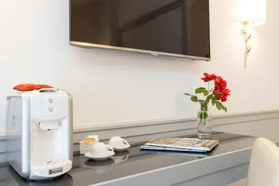 a kitchen counter with a coffee maker and flowers on it at Hotel Della Conciliazione in Rome