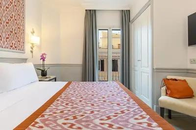 a bedroom with a bed and a couch and a window at Hotel Della Conciliazione in Rome