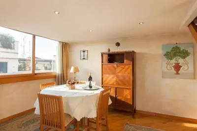 a dining room with a table and chairs and a window at Amazing panoramic artist's loft Spanish Steps in Rome