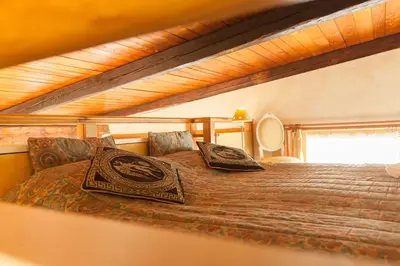 a bedroom with a large bed in a wooden ceiling at Amazing panoramic artist's loft Spanish Steps in Rome