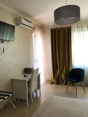 a living room with a desk and a table and chairs at Isabel in Rome
