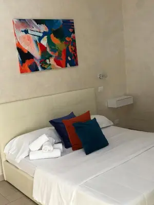 a bedroom with a white bed with colorful pillows at Isabel in Rome