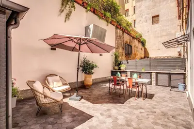 a patio with a table and chairs and an umbrella at DeCharme apartment with terrace in Monti in Rome