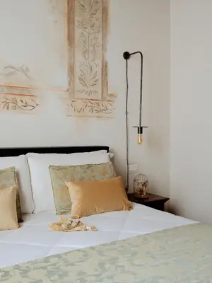 a bed with white sheets and pillows in a bedroom at Relais Giulia in Rome
