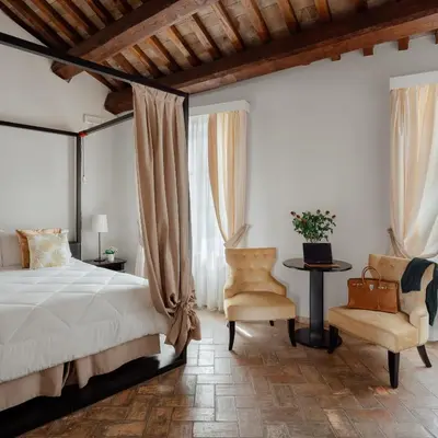 a bedroom with a bed and a chair at Relais Giulia in Rome