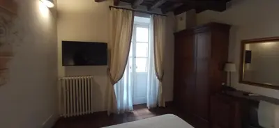 a bedroom with a bed and a window and a television at Relais Giulia in Rome