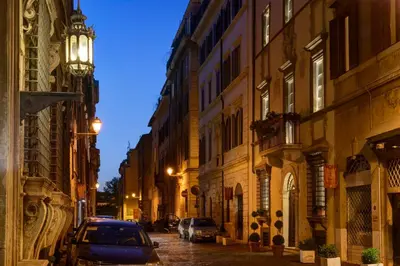 a city street at night with cars parked on the street at Relais Giulia in Rome
