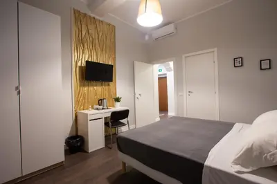 a bedroom with a large bed and a kitchen at maribea rome center in Rome