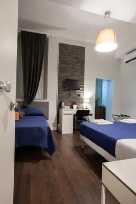 a bedroom with a blue and white bed with towels on it at maribea rome center in Rome