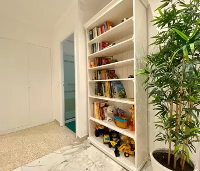 a book shelf filled with toys and a potted plant at Elegant Vatican Metro & Golf Rome in Rome