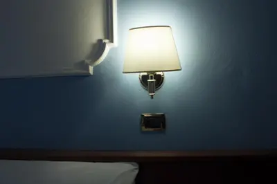 a lamp on a blue wall in a hotel room at Clara Domus in Rome