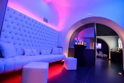 a living room with a white couch and pink lights at THE ONE Boutique Hotel & SPA Roma in Rome