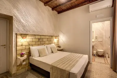 a bedroom with a large bed and a bathroom at Colosseo Accomodation Room Guest House in Rome