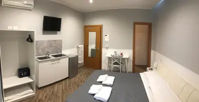 a room with a kitchen and a table with towels at Rent Rooms Colosseum in Rome
