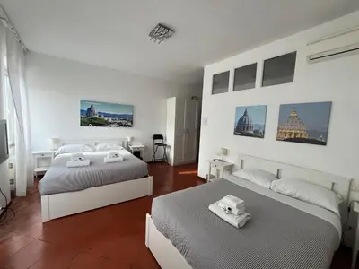 two beds in a white room with white walls at Vista Cupola House in Rome