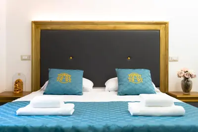 a large bed with blue sheets and blue pillows at Art Atelier Borgo in Rome