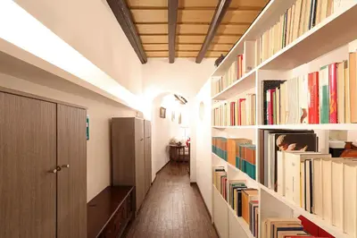 a hallway with white shelves filled with books at Loft In Rome Termini-Colosseum in Rome