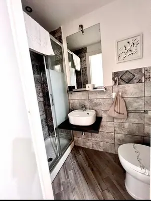 a bathroom with a sink and a toilet and a mirror at Spagna Rooms in Rome