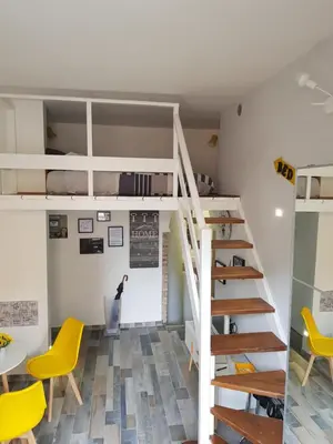 a room with a loft bed and yellow chairs at La Roma di Camilla in Trastevere in Rome