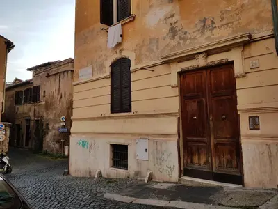 an old building with a wooden door on a street at La Roma di Camilla in Trastevere in Rome