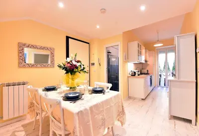 a dining room with a table with a vase of flowers on it at Jubilee 3 Luxury apartment in Rome Vatican in Rome