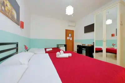 a bedroom with two beds with a red blanket at Dandi Domus in Rome