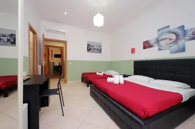 a bedroom with two beds and a desk in it at Dandi Domus in Rome