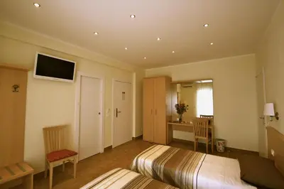 a hotel room with two beds and a television at Alba Romana in Rome