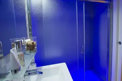 a blue bathroom with a sink and a mirror at Borghese Executive Suite in Rome