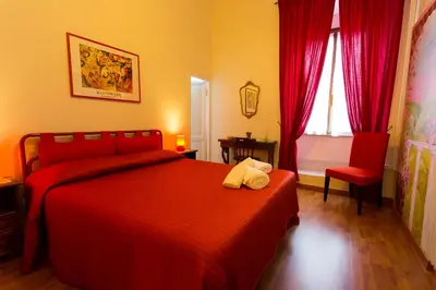 a bedroom with a red bed and a red chair at Laterano Inn in Rome
