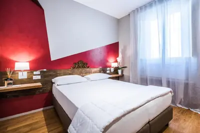 a bedroom with a white bed and a red wall at Giselda Home in Rome
