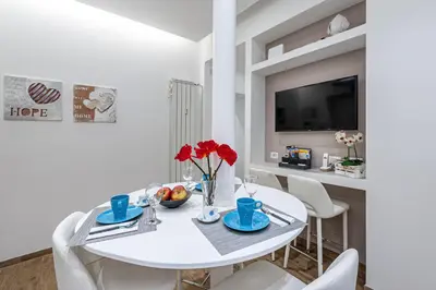 a white dining room with a white table and chairs at St. Peter's Refuge 2 in Rome