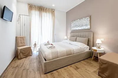 a bedroom with a large bed and a chair at St. Peter's Refuge 2 in Rome