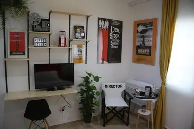 a room with a television and a desk with chairs at Mila Guest House in Rome