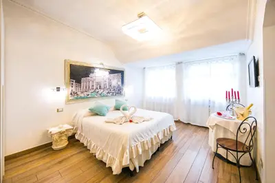 a bedroom with a bed and a painting on the wall at Suites Roma Tiburtina Economy in Rome