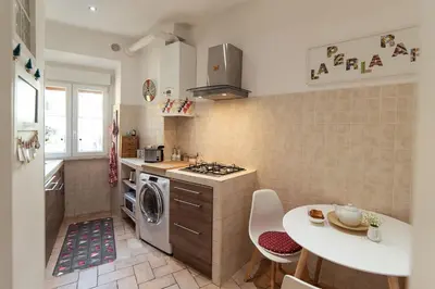 a kitchen with a washer and dryer and a table at LA PERLA RARA Vatican Sweet Home in Rome