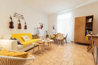 a living room with a yellow couch and a table at LA PERLA RARA Vatican Sweet Home in Rome