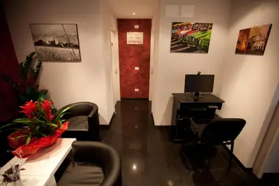 a waiting room with chairs and a table and a television at Heart of Rome Rooms in Rome