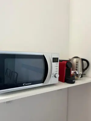 a microwave sitting on top of a shelf at Le Naiadi in Rome
