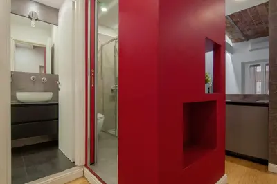 a red wall in a bathroom with a sink at Urbanflat Repubblica Square in Rome
