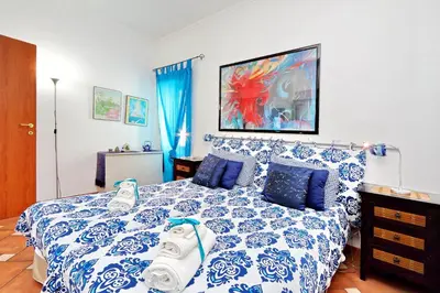 a bedroom with a bed with a blue and white comforter at THE ROMAN NEST ai Musei Vaticani in Rome